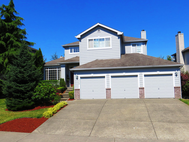 this is a home with trees and a driveway