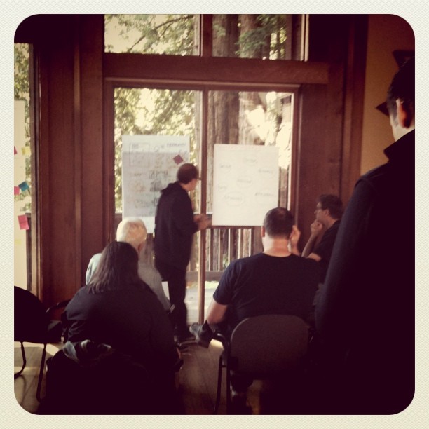 a group of people are sitting and listening to an instructor