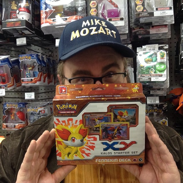 a man holding up a pokemon trading card
