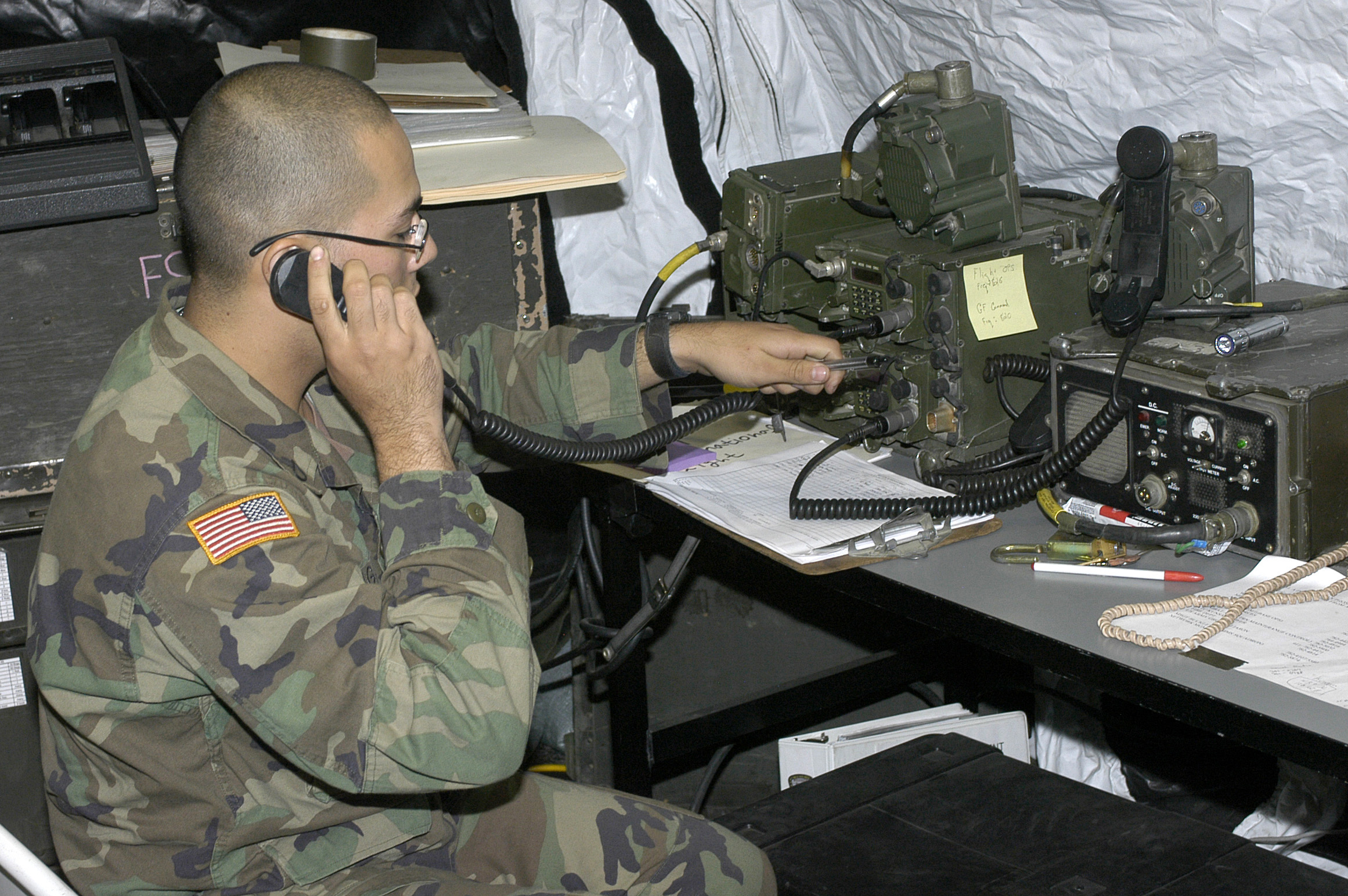 a soldier is sitting down talking on the phone