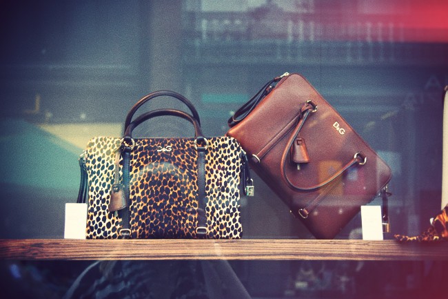 two different purses sitting on display in a window