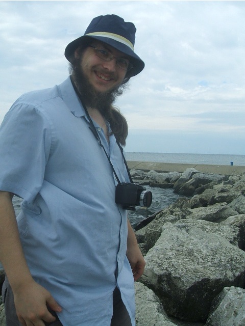 a man with a camera on a rocky beach