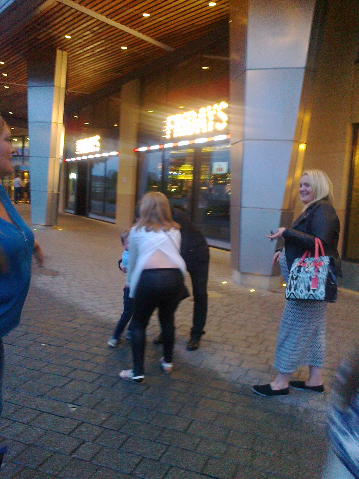 a group of women walking on the sidewalk outside a building