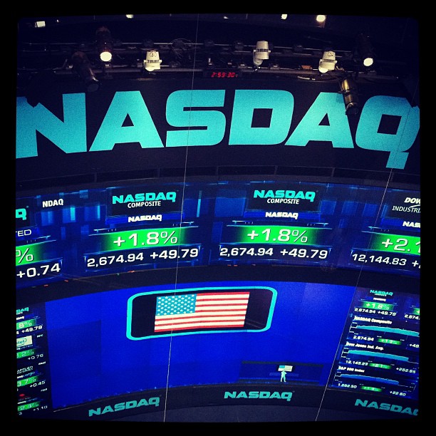 the nasdaq sign is shown with a large american flag in the center