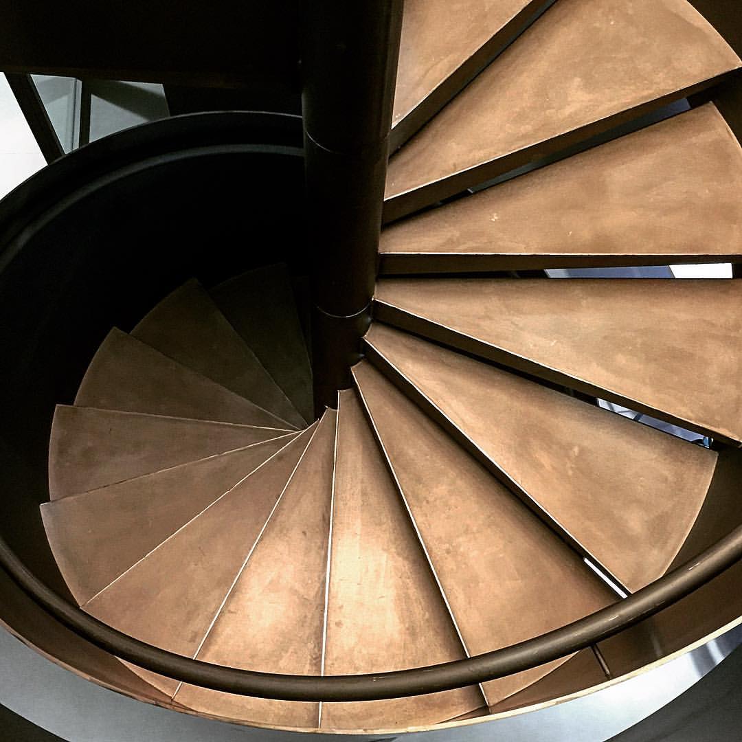 looking down the spiral stairs on the top of a building