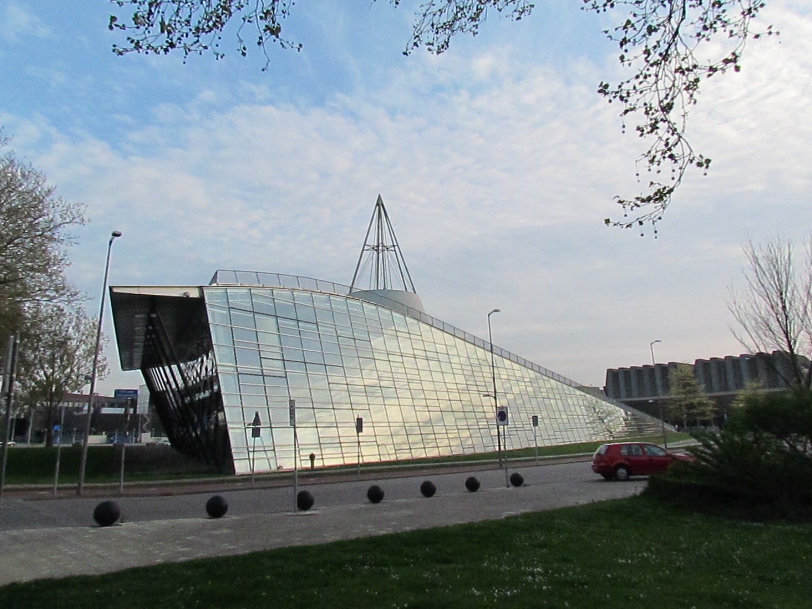 a modern building with mirrored walls and green grass