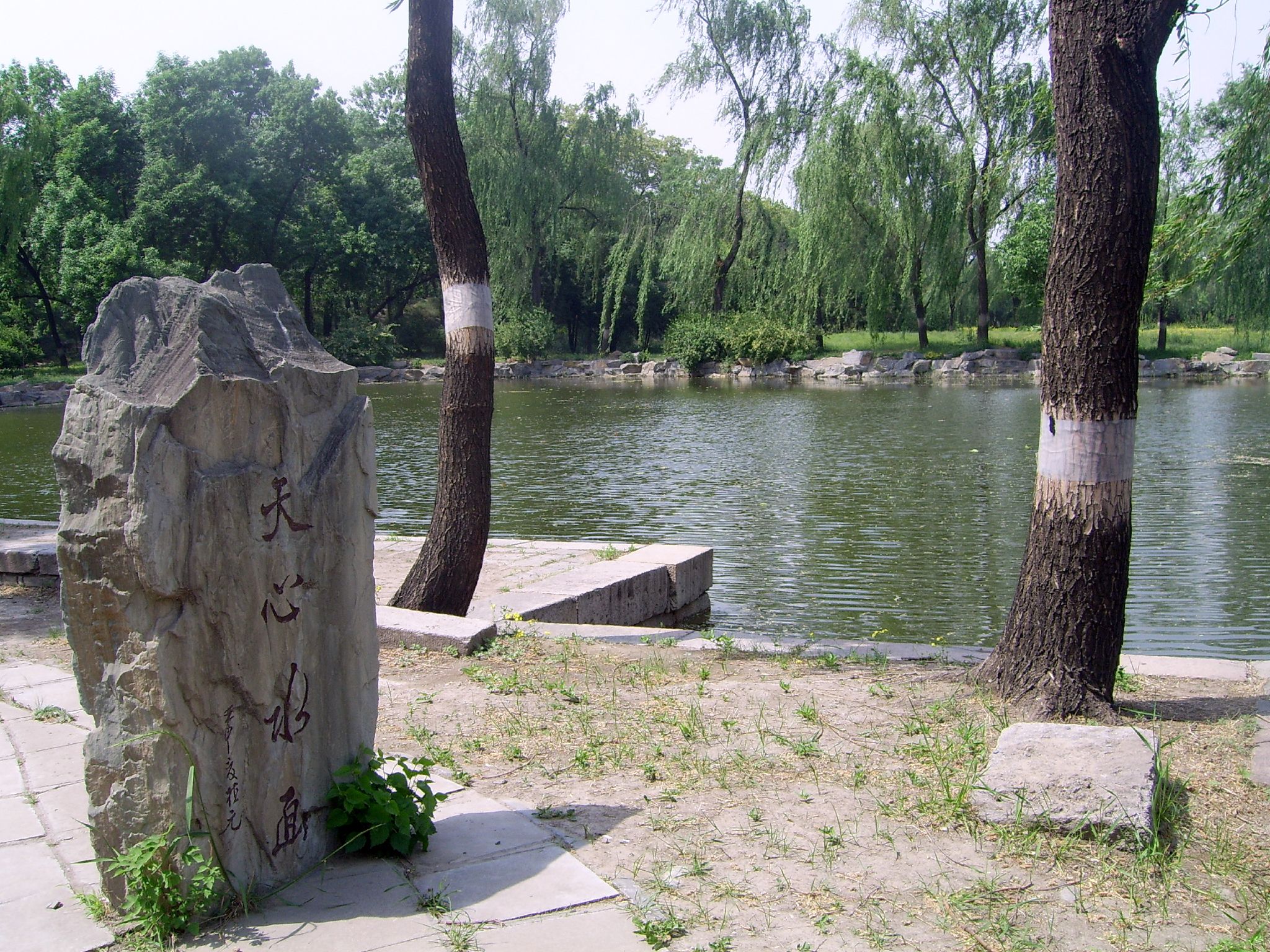 a stone statue sitting by a small body of water