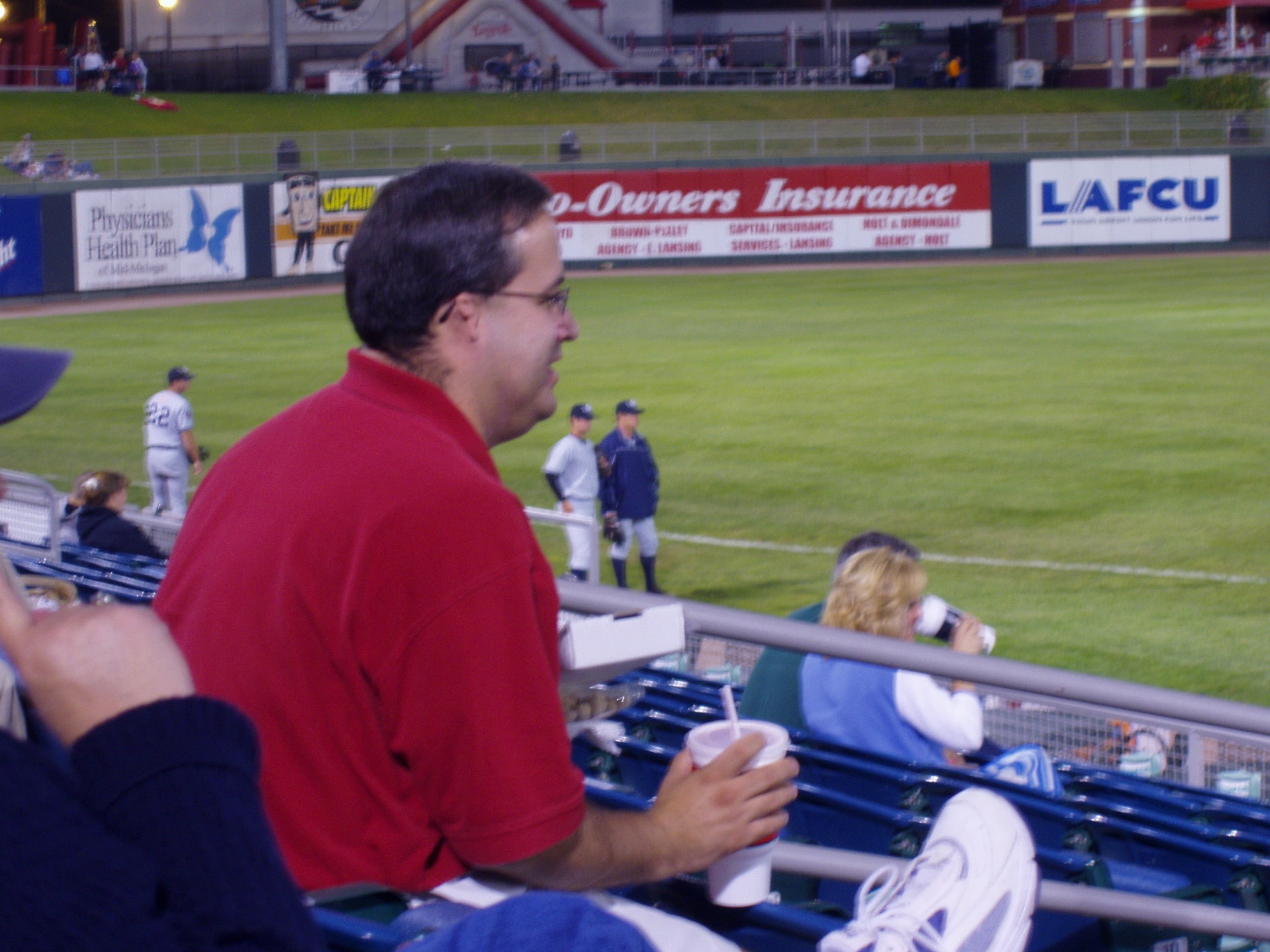 two men sitting at an empty baseball stadium