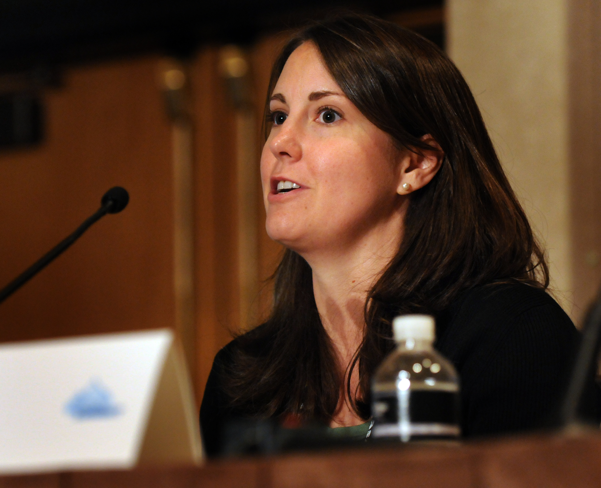 a woman is giving a speech in front of a microphone