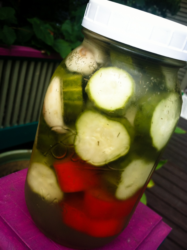 pickles in a large jar with plastic top