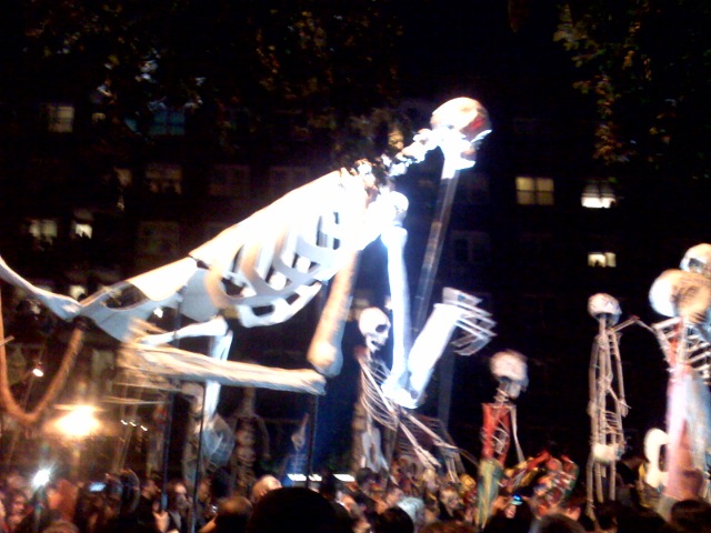 a parade float with skeleton figurines in the background