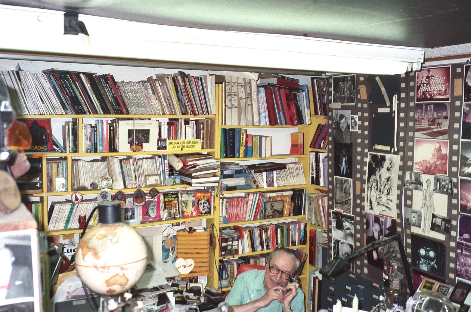 a man sitting in front of a book shelf filled with books