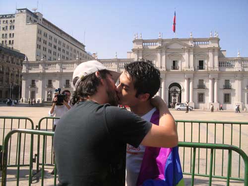 a couple kissing each other in front of a white building