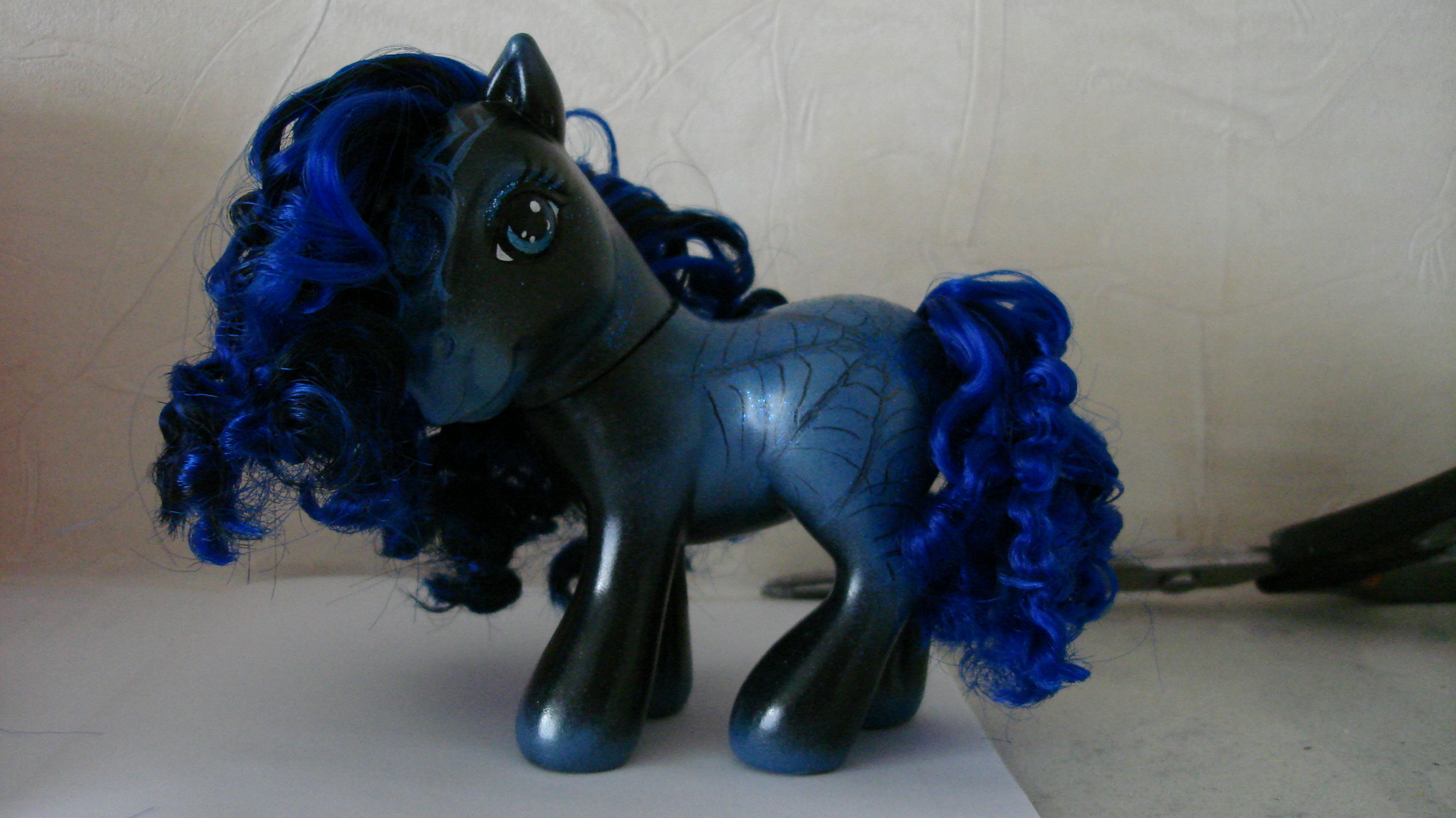 an image of a black pony with blue hair