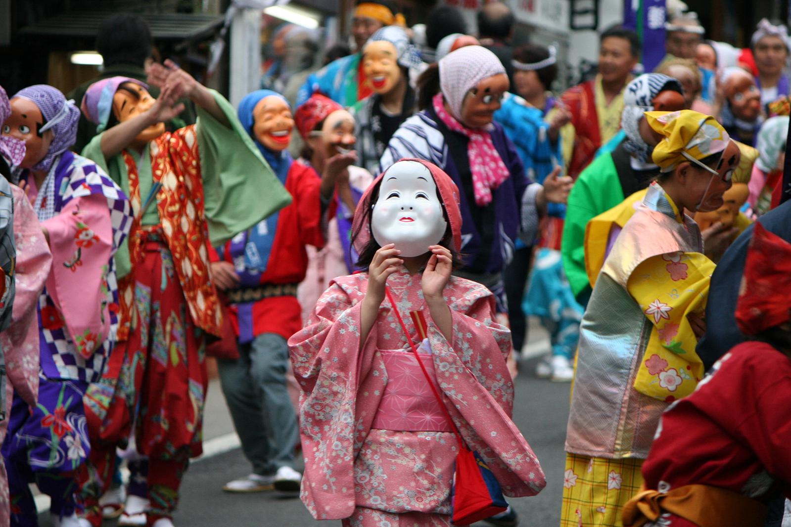 several people with a mask in their hand on the street