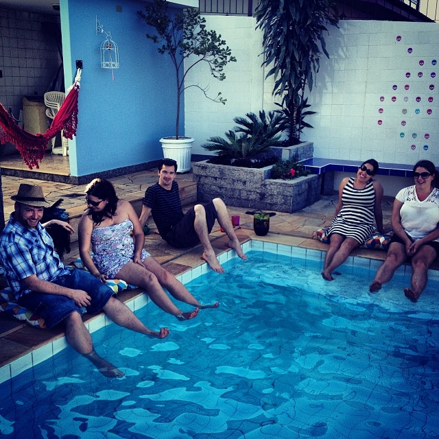 several people sit in a swimming pool with blue water