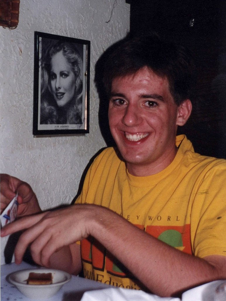 a man smiling for a picture with a bowl of food