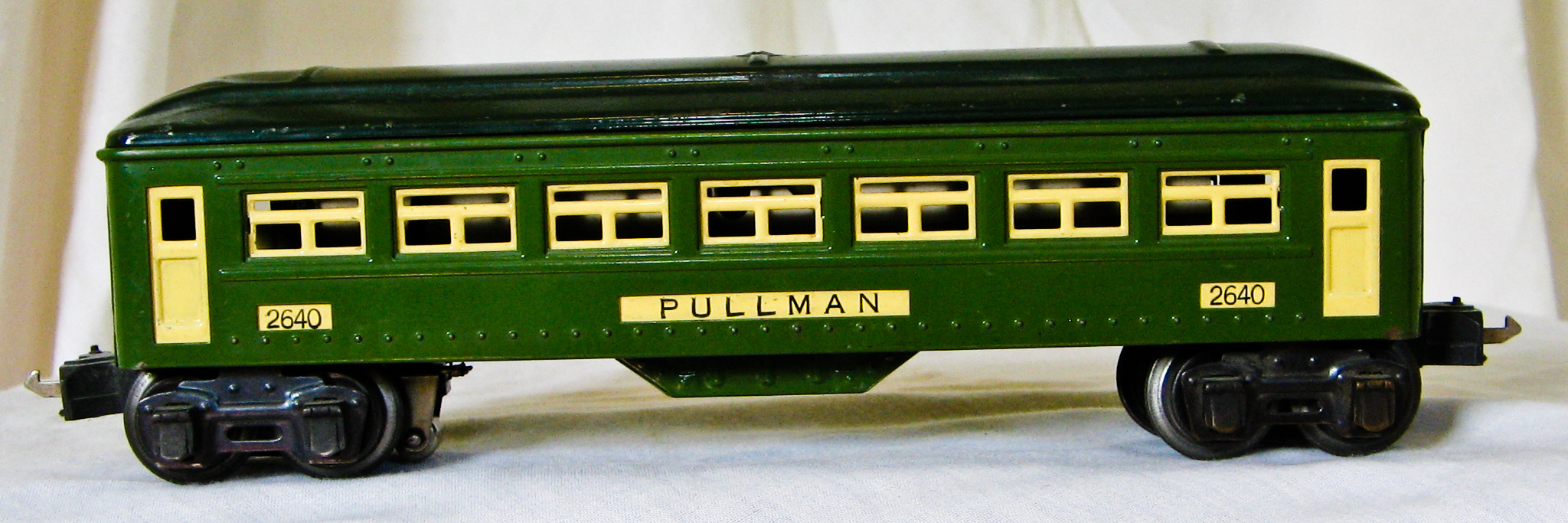 a toy green train car sitting on top of a white table