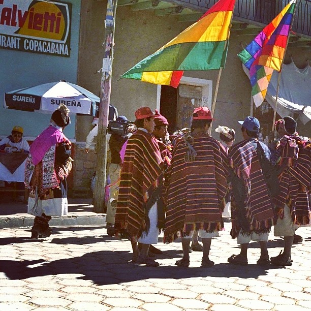 a group of men wearing colorful dress standing on a street
