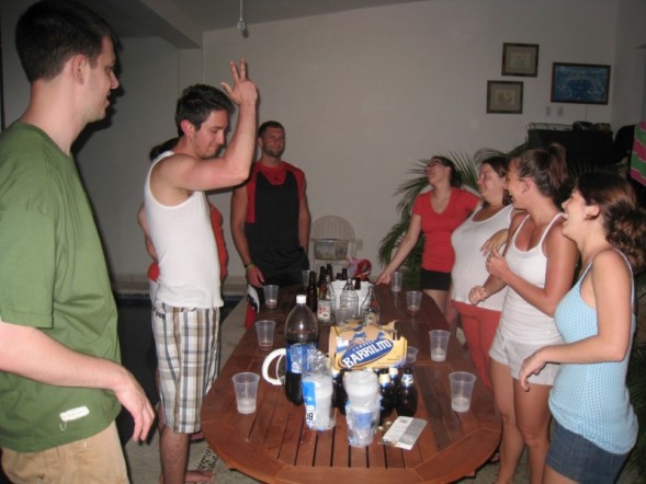 a group of people standing around a table and some drinks