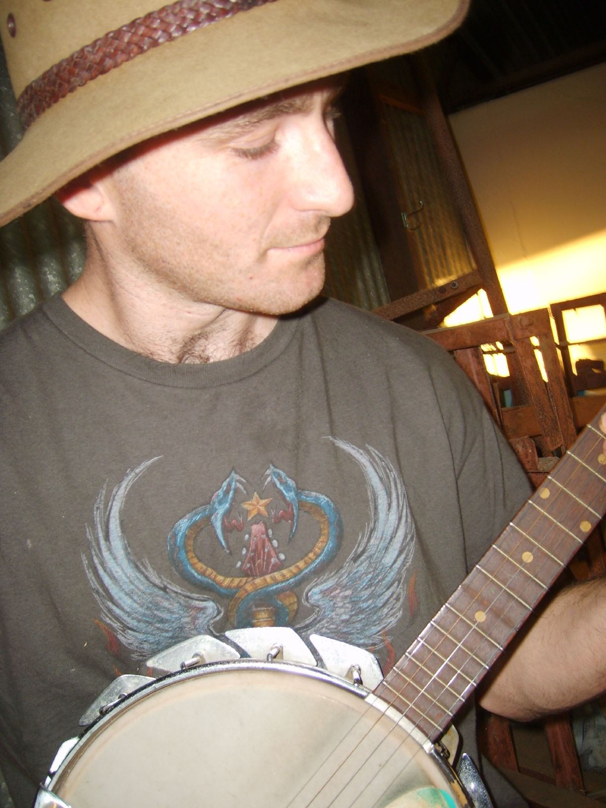 a man with a hat is playing a guitar