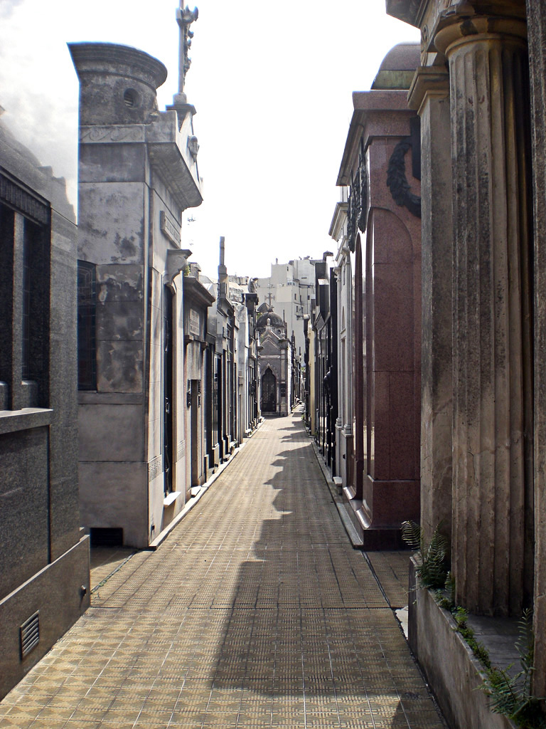 long narrow cobblestone street lined with large pillars