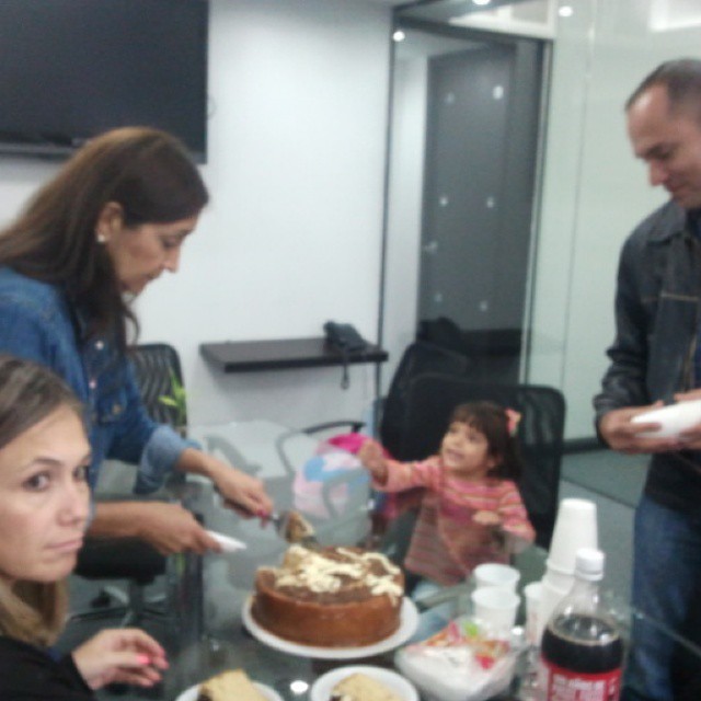 a family gathering around the cake, to eat it