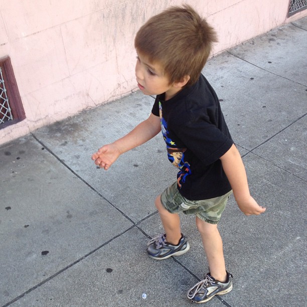 a little boy walking down the street