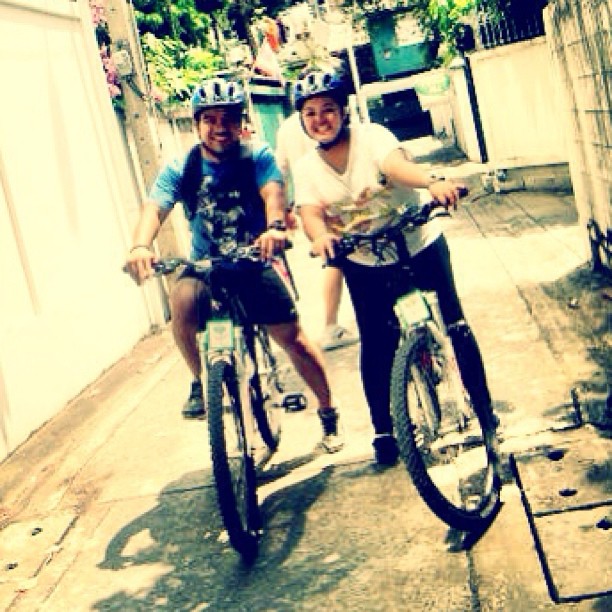 two people are riding bicycles on a path