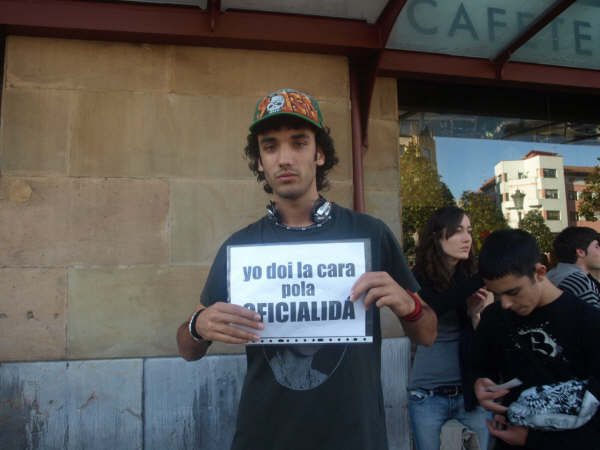 young man with sign in front of a building that says no ioi la carara