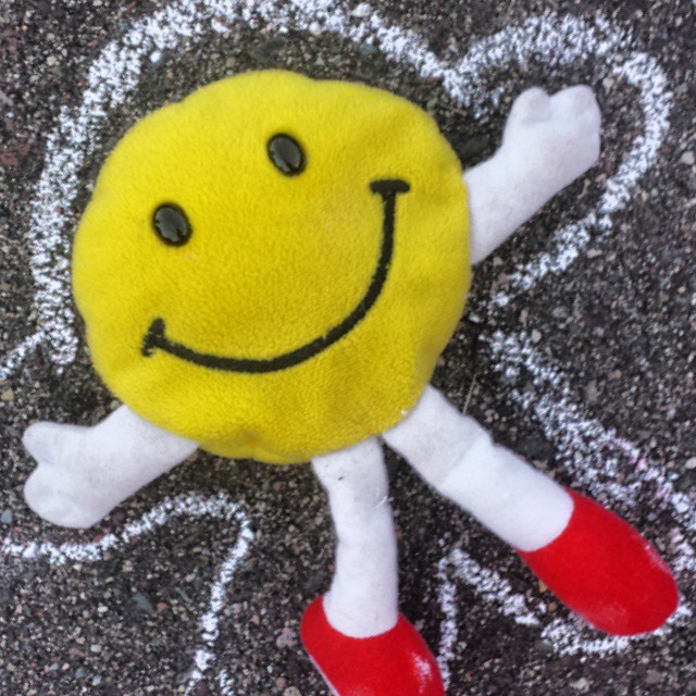 a smiling toy with red boots on it