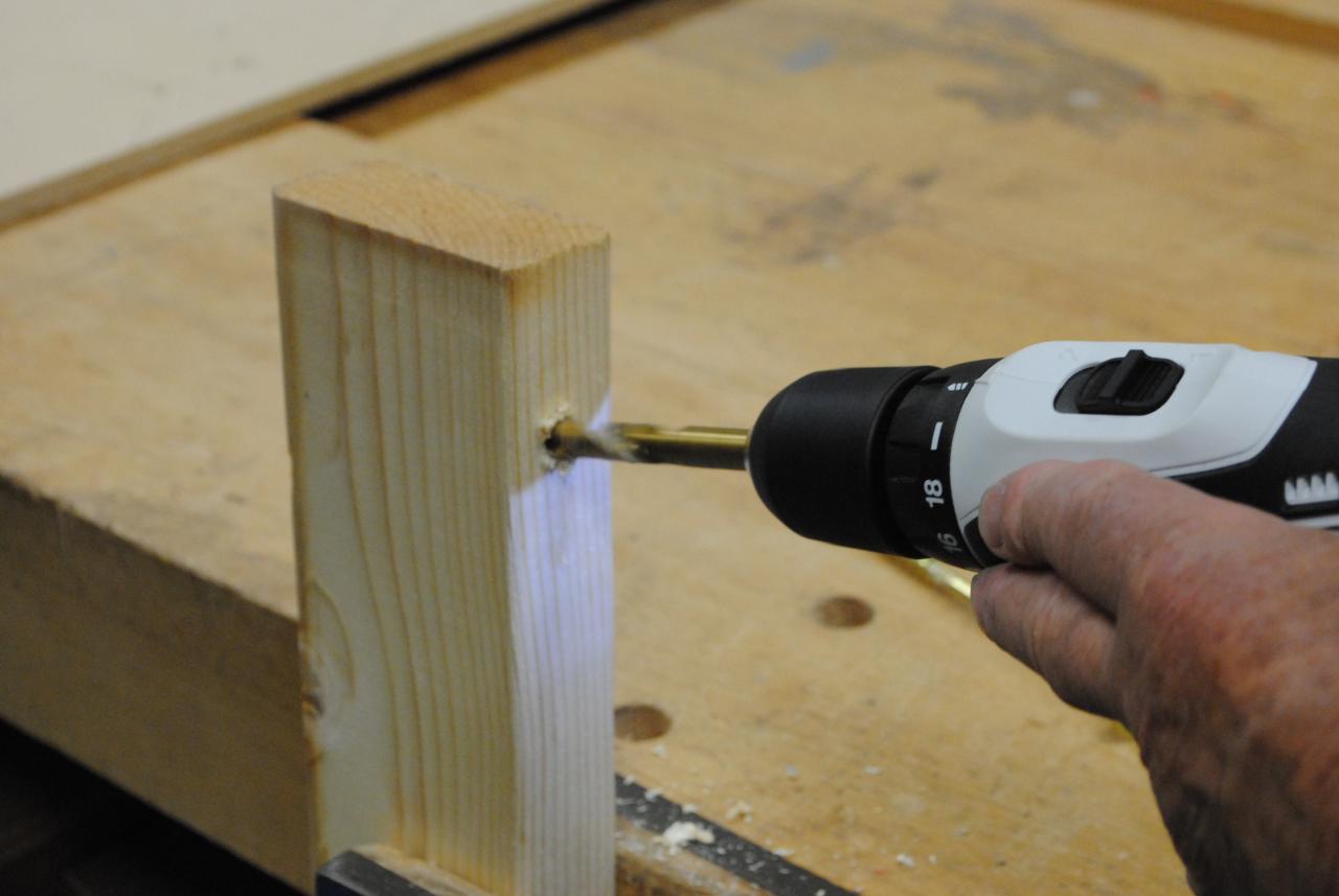 a person uses a cordless drill on a piece of wood
