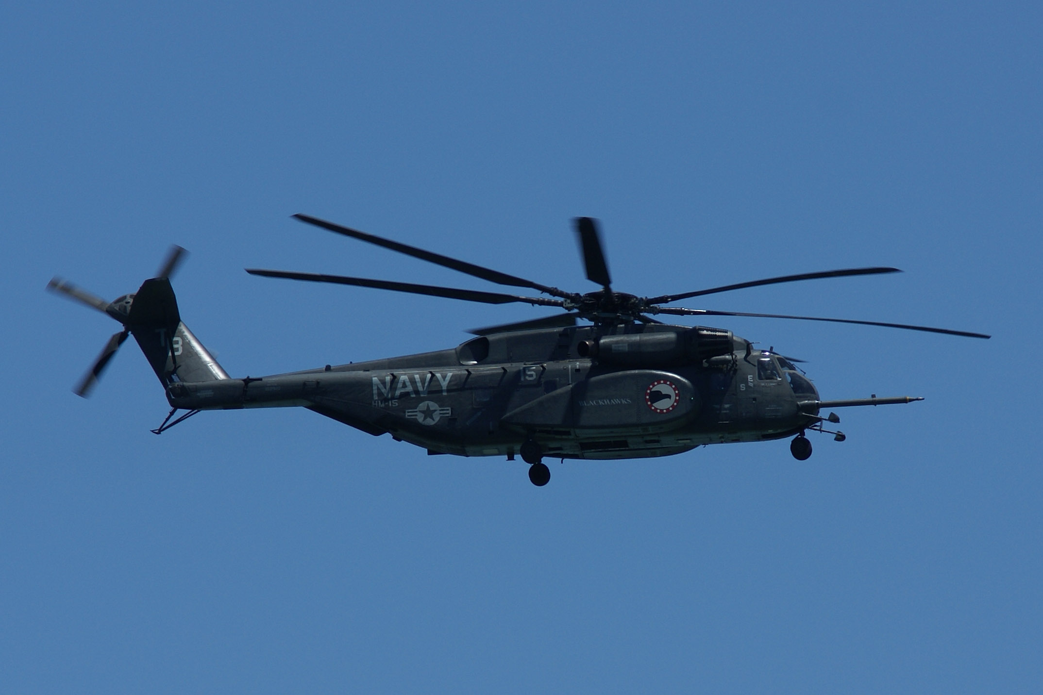 an army helicopter flying in a clear blue sky