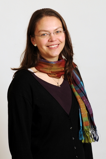 a woman in glasses is smiling at the camera