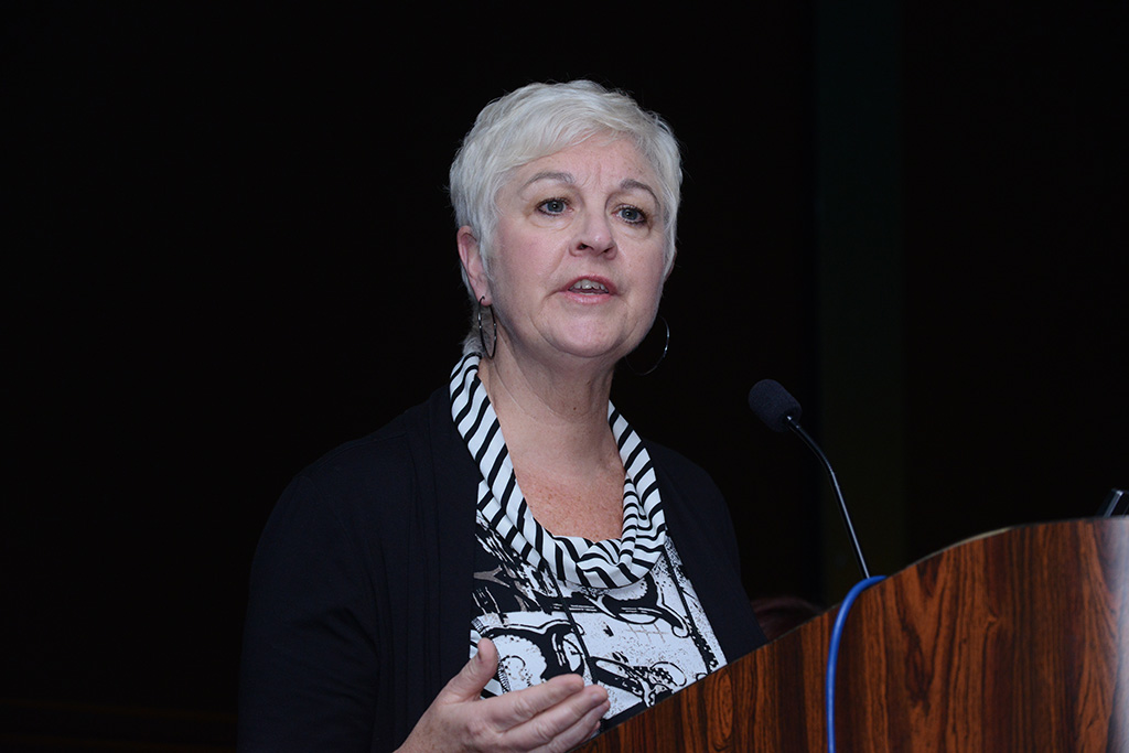 a woman with short white hair giving a speech