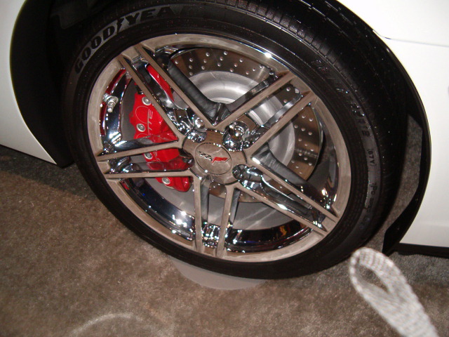 a white car with red ke rotors and chrome rims