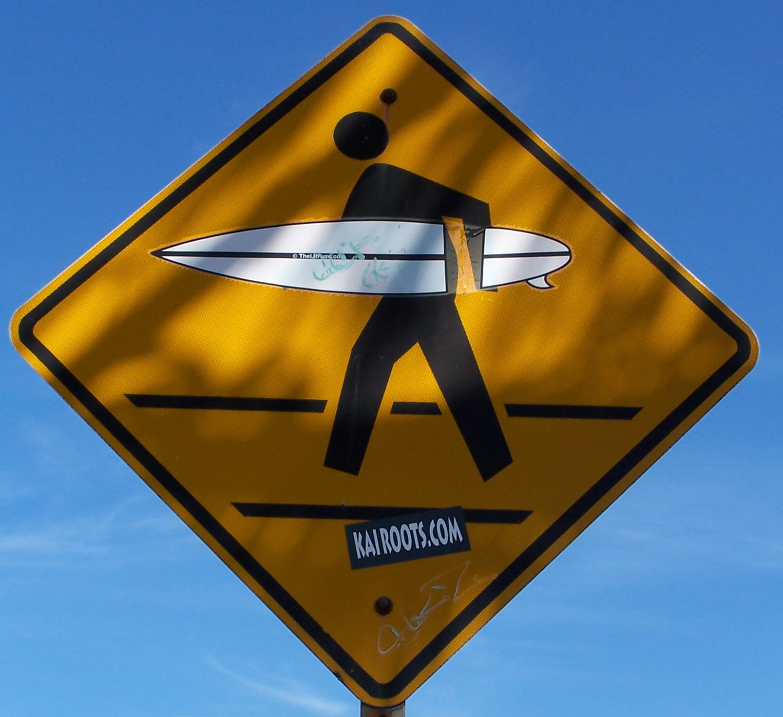 a yellow road sign showing a person holding a surf board