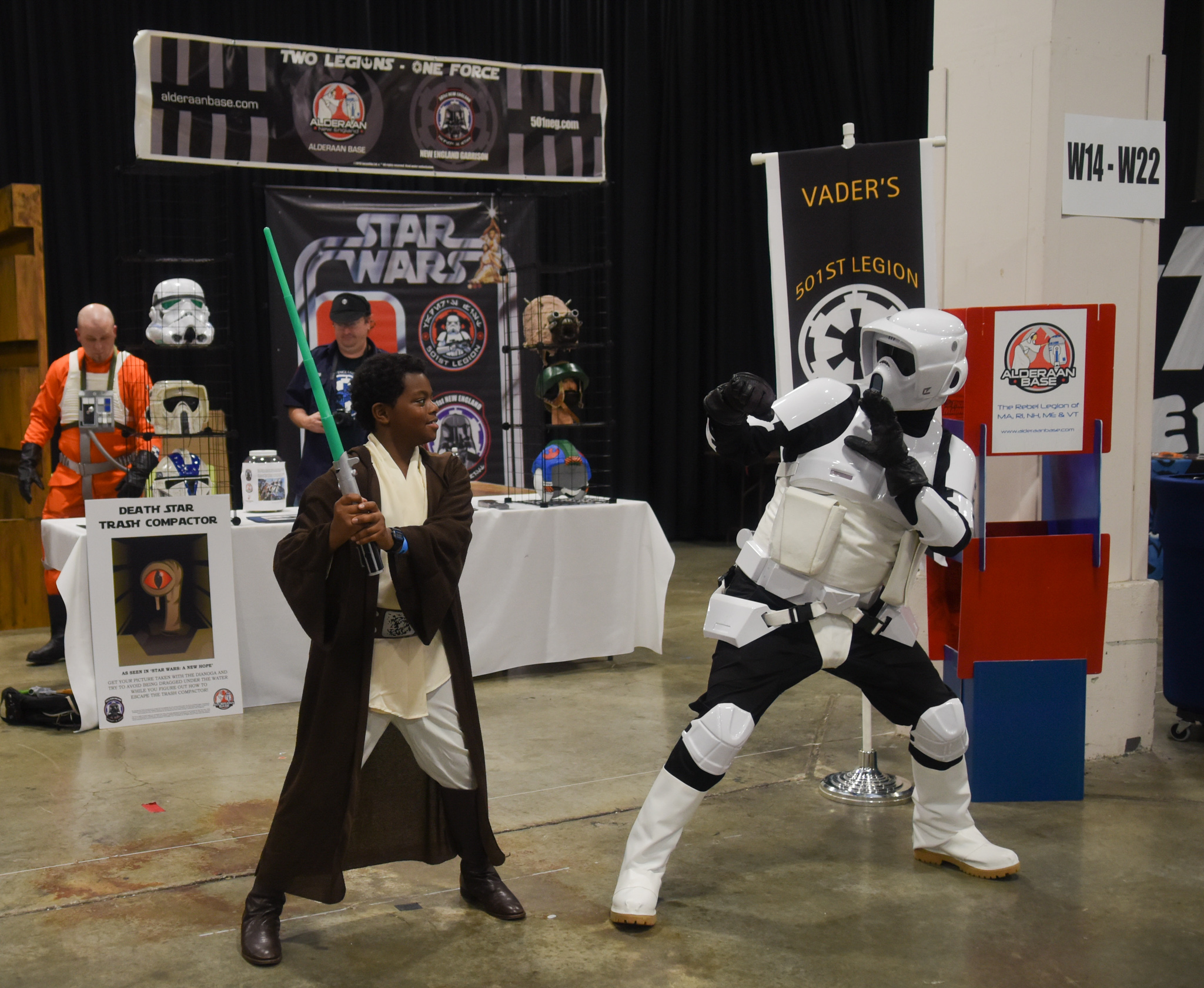 a man in star wars costume standing near a person with a sword