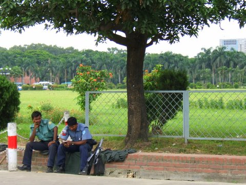 two men sitting next to each other talking on the street