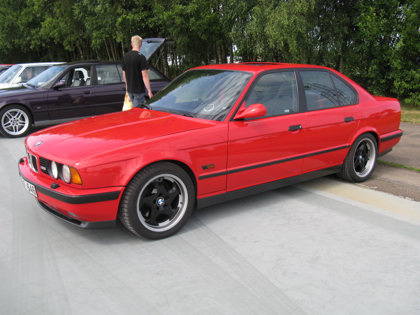 an all red bmw is parked in a lot