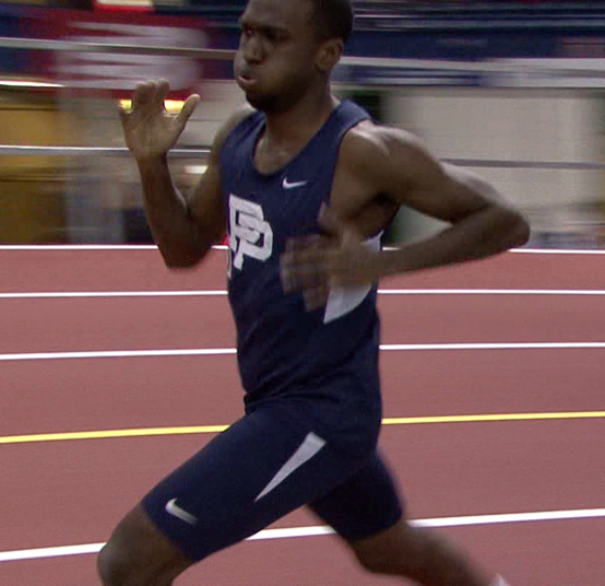 a man running on an indoor track with motion blurry