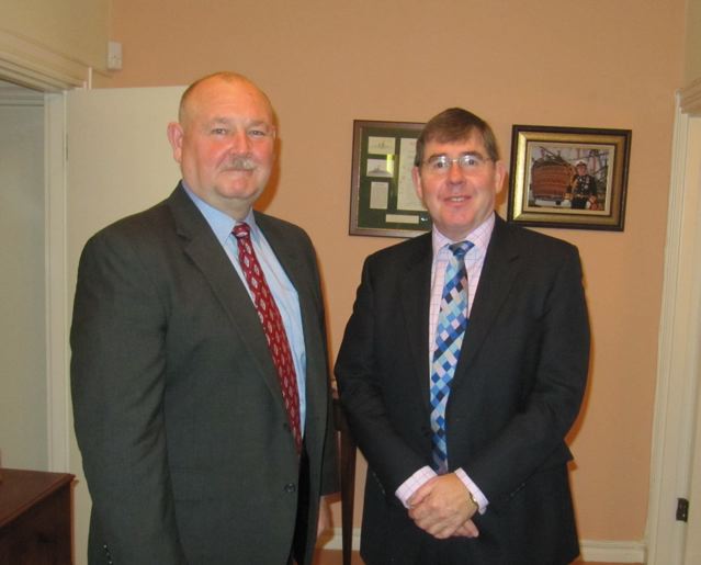 two older men pose together in suits and ties