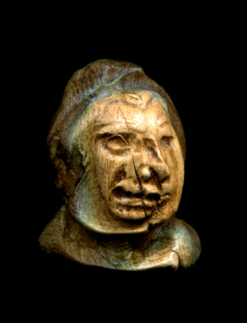 a carved head on a black background
