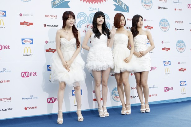several pretty young ladies in white dresses posing on blue carpet