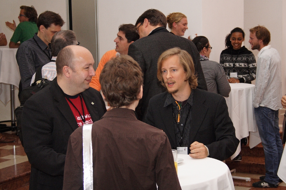 people gathered in a group around white tables