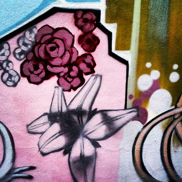 a close up of a wall with art and flowers