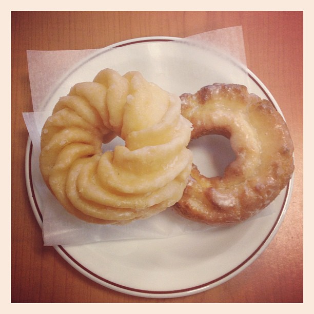 three donuts sitting on a white and black plate