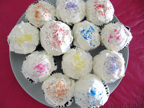 a plate with cupcakes that have been painted rainbow