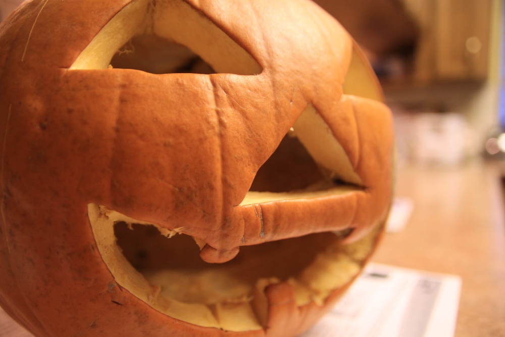 an ugly halloween pumpkin with the word ghost written on it