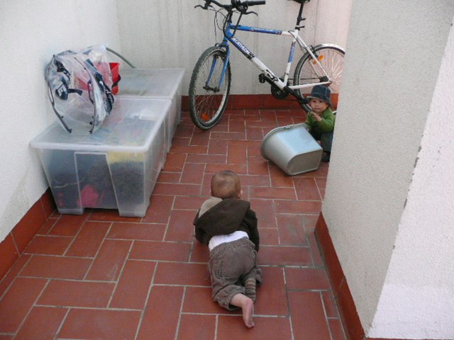 a young baby plays outside while sitting on the floor